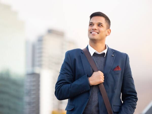A young smiling businessman in front of Bulgarian real estates.