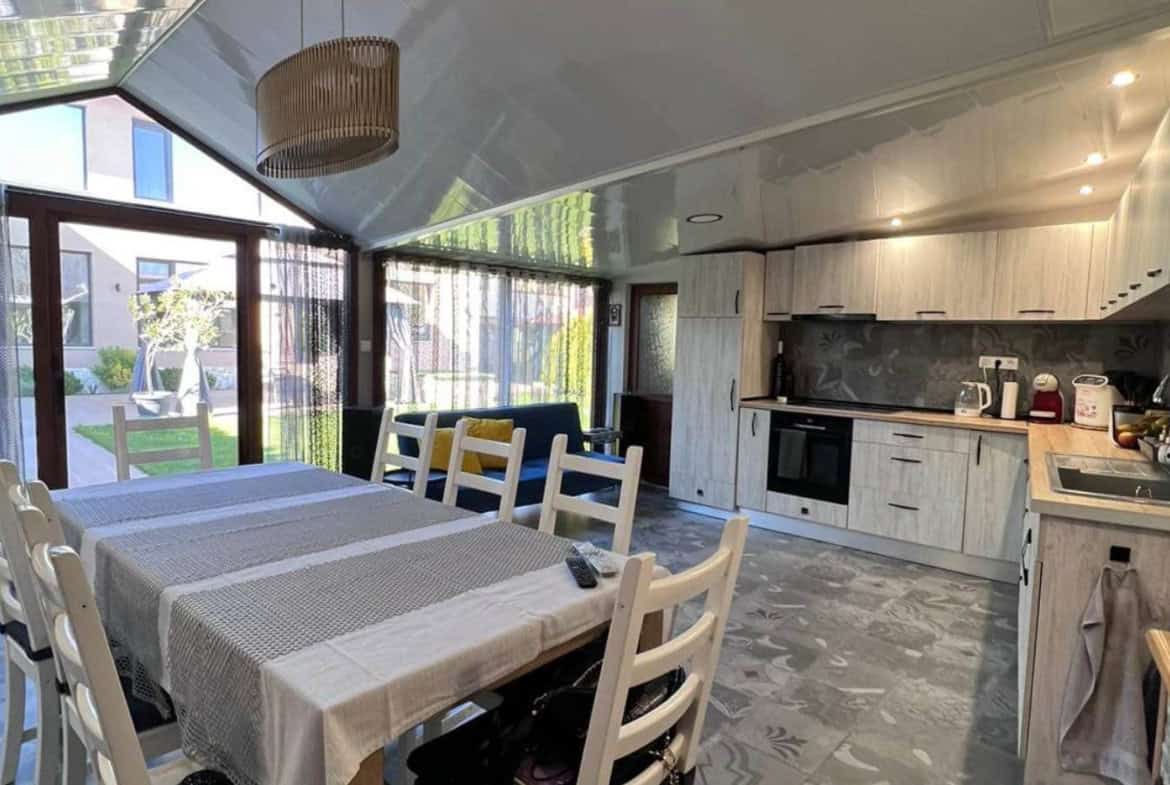 Summer kitchen with an eight seat table and a small couch