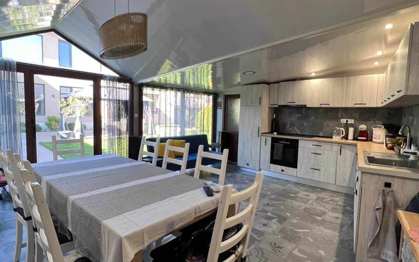 Summer kitchen with an eight seat table and a small couch