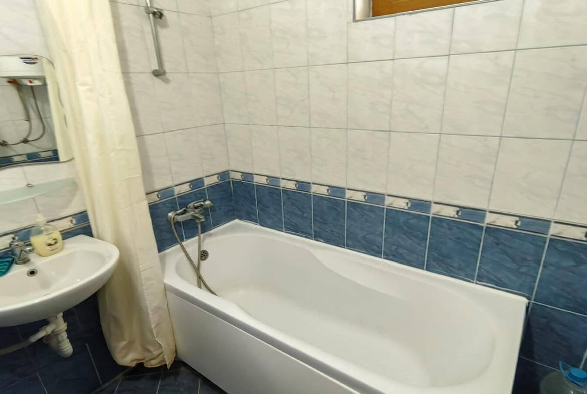 Баня с бяла вана и синьо-бели плочки.