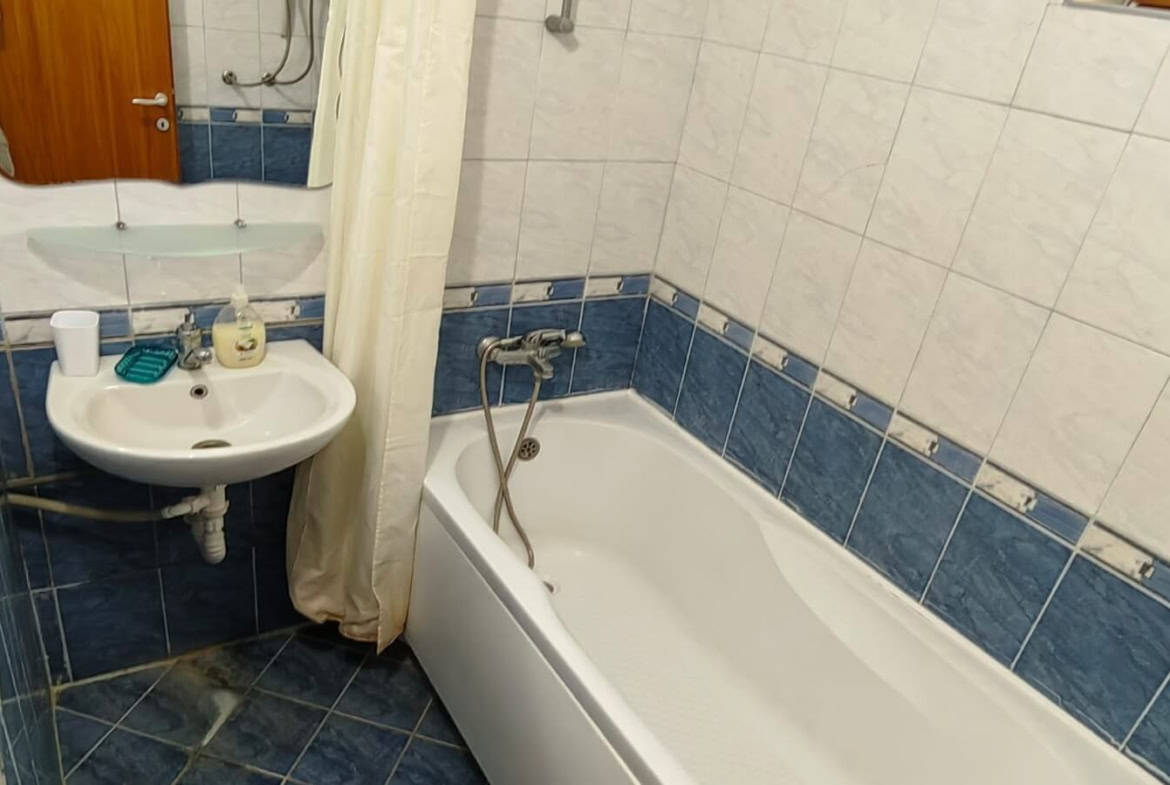 Баня с бяла вана и синьо-бели плочка.