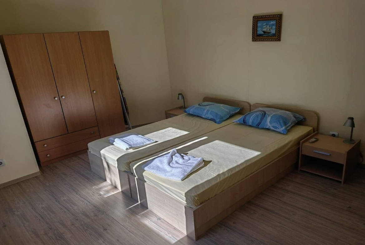 Twin bedroom with large brown wardrobe.