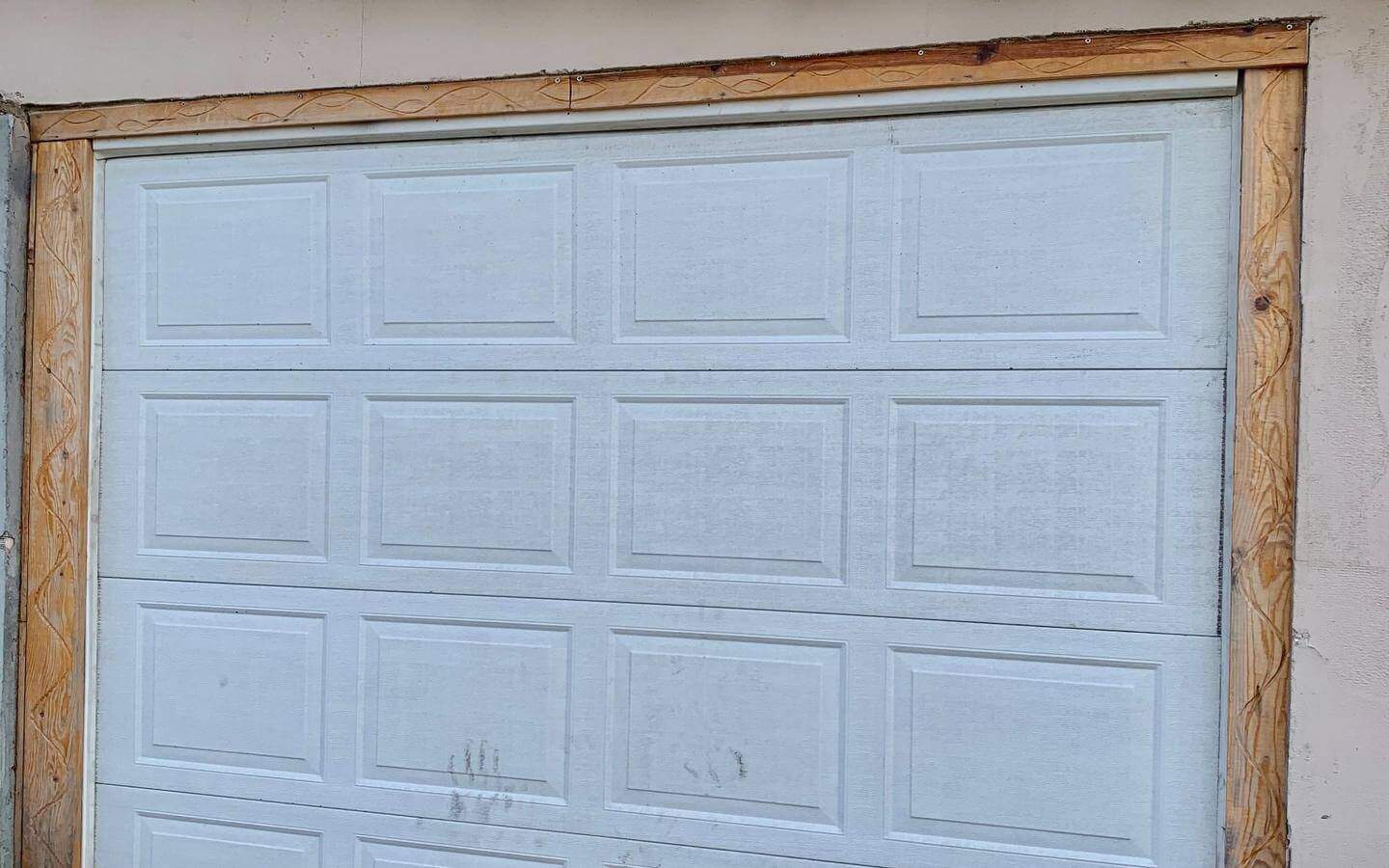 kushta-prodajba-kostinbrod-sofia-10 Затворена гаражна врата, около която има видими следи от употреба и износване.