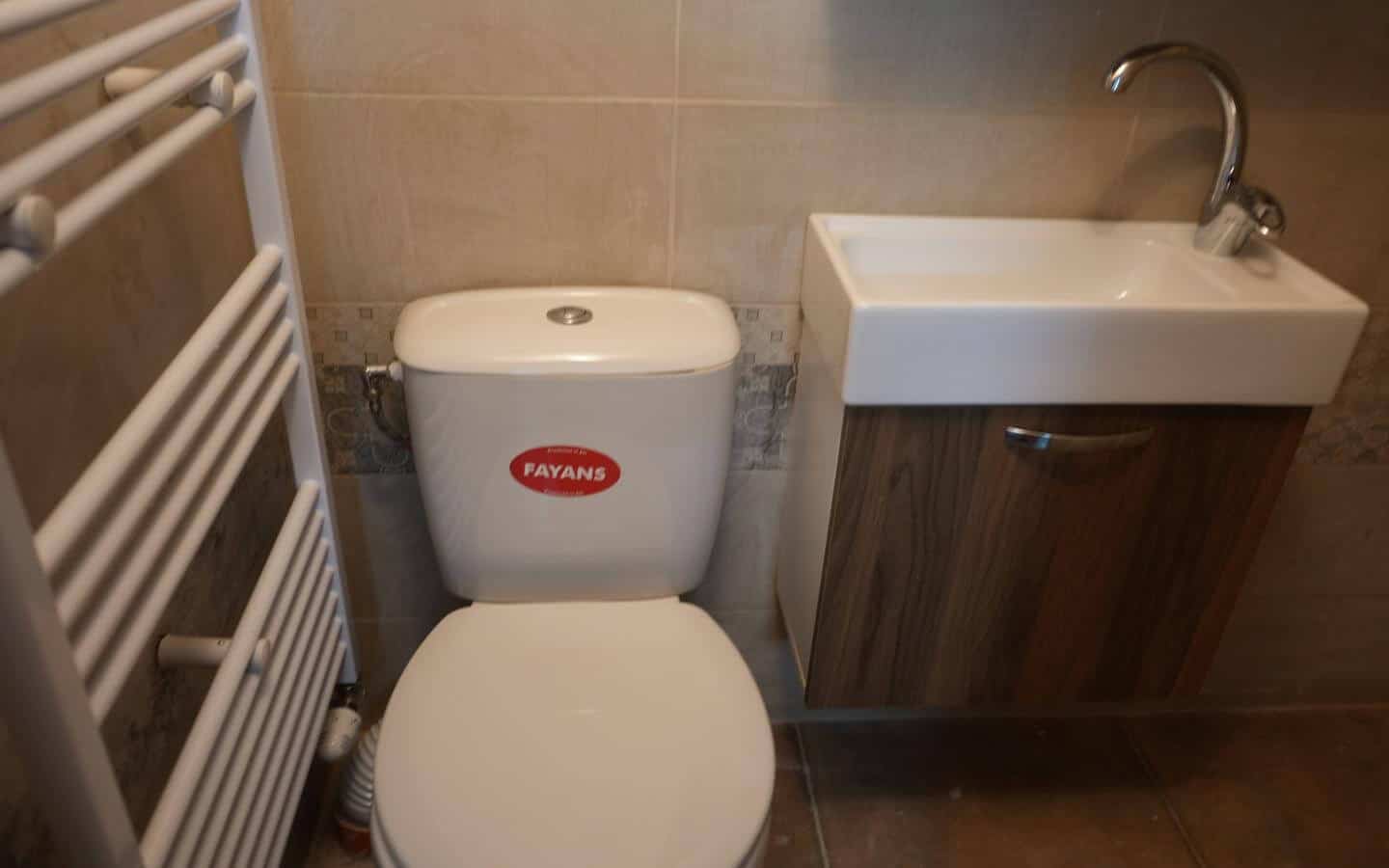 kushta-za-prodajba-kostenec-veranda-4 Баня с бял санитарен фаянс и дървени шкафчета.