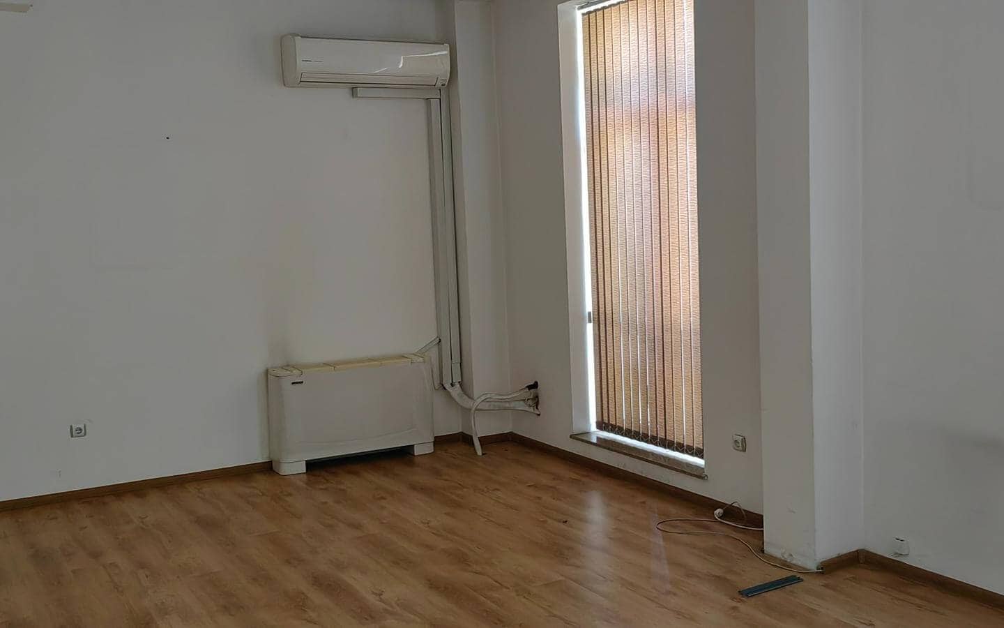 Празна стая с климатик и щори от офис под наем в София до Централни хали.
