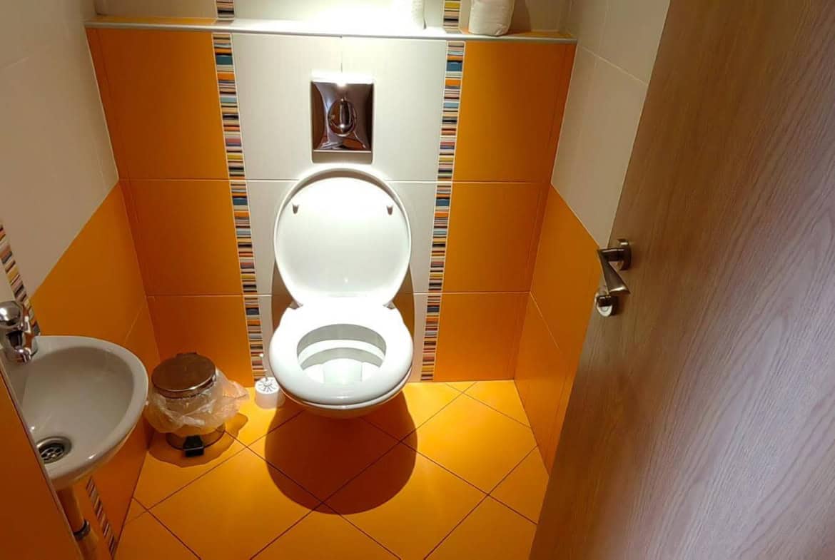 алка баня с оранжеви плочки и тоалетна от офис под наем в София до Централни хали.