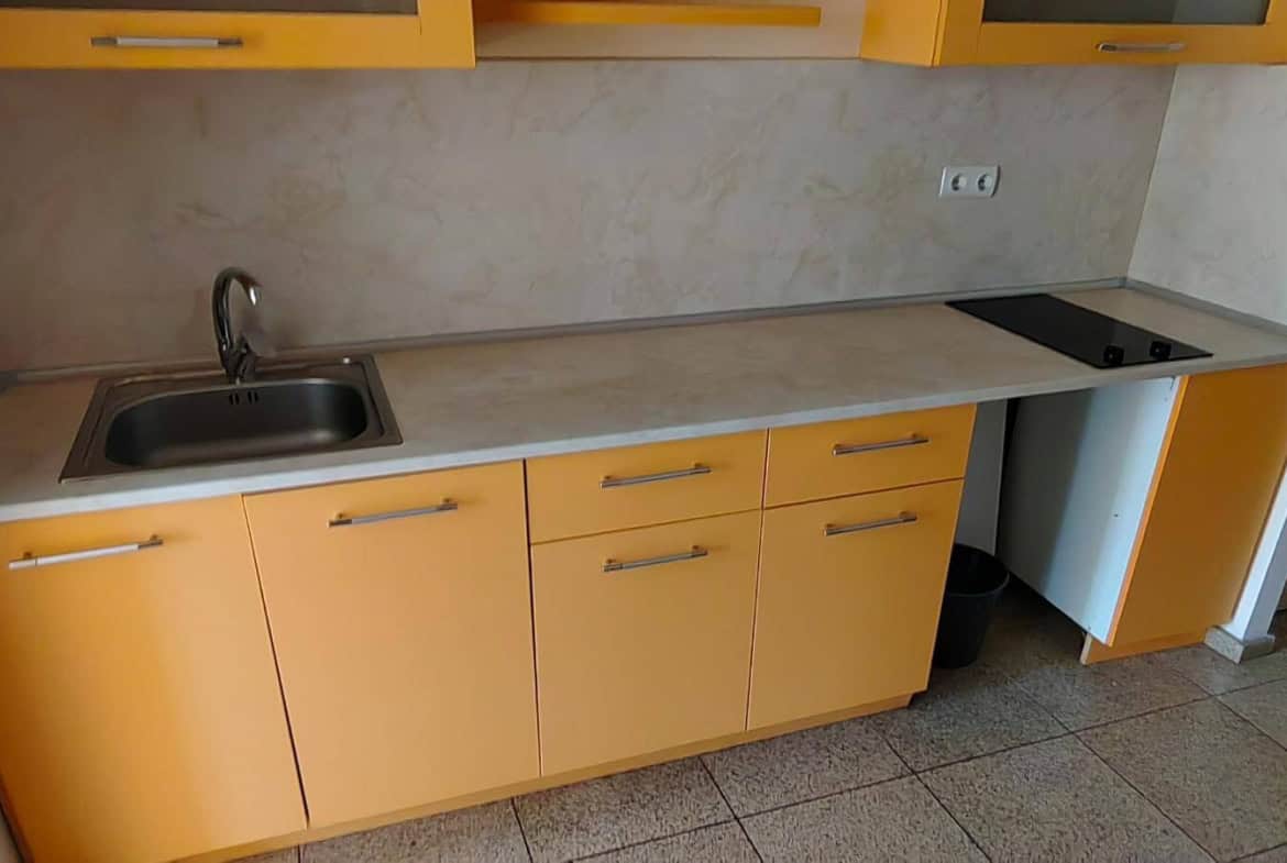 Малка кухня с оранжеви шкафове и мивка от офис под наем в София до Централни хали.