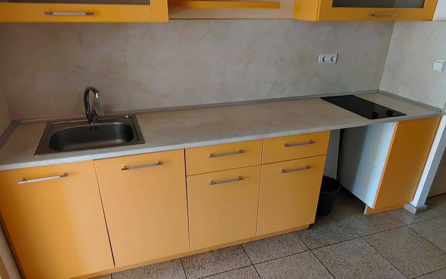 Малка кухня с оранжеви шкафове и мивка от офис под наем в София до Централни хали.