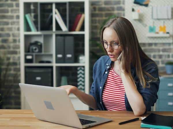 A real estate owner woman wondering about managing her property in front of her laptop.