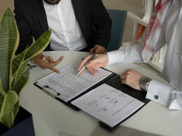 Two people signing an agreement contract in an office.