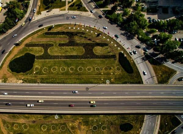 Aerial top view of a roundabout and a highway passing through.