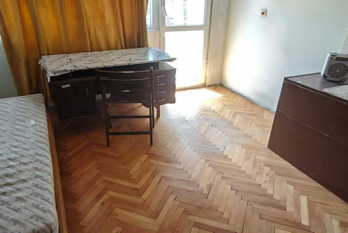 Стая с легло, бюро, стол и голям прозорец с пердета.