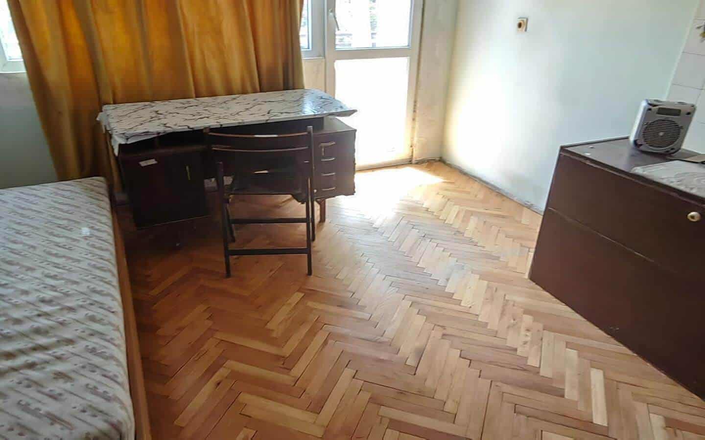 Стая с легло, бюро, стол и голям прозорец с пердета.