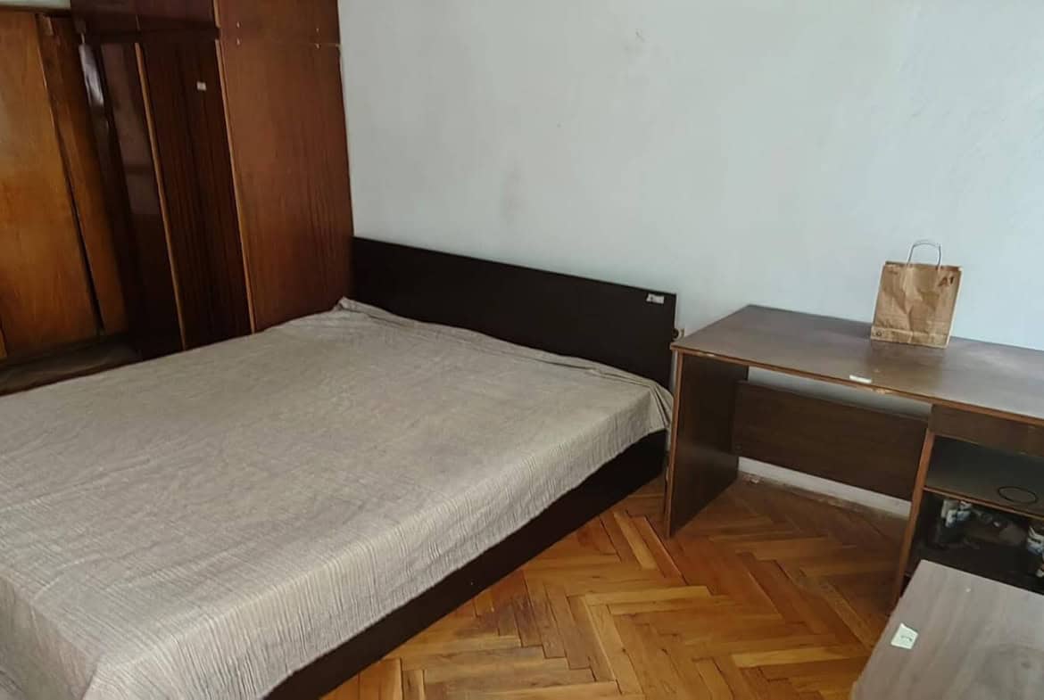 Спалня с голямо легло, бюро и голям шкаф.