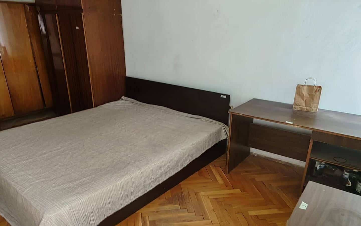 Спалня с голямо легло, бюро и голям шкаф.