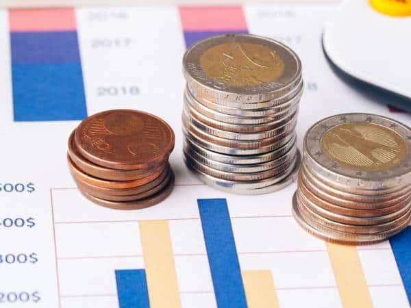 Stacks of Euros coins on graphs and charts.