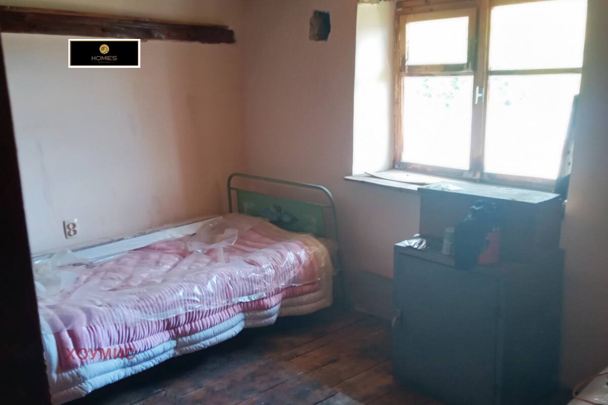 Furnished bedroom with window and wooden flooring