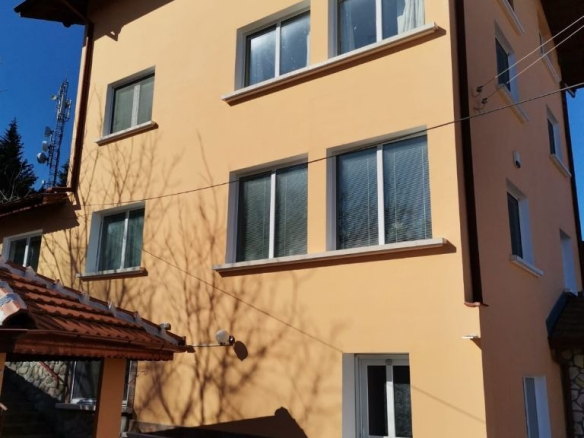 Yellow three-story house with brown tiled roof