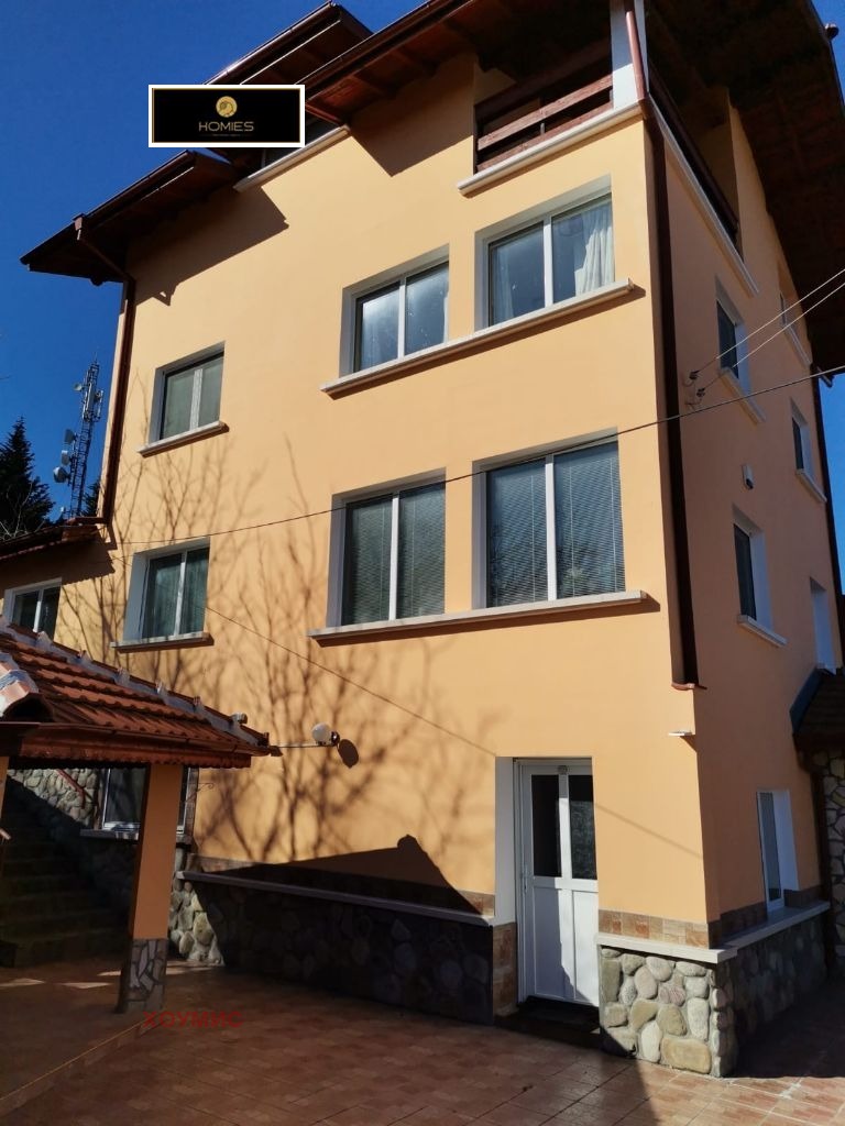 Yellow three-story house with brown tiled roof