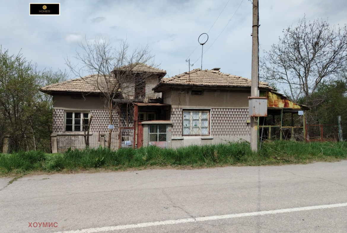 Фронтален поглед на стара селска къща със счупени прозорци