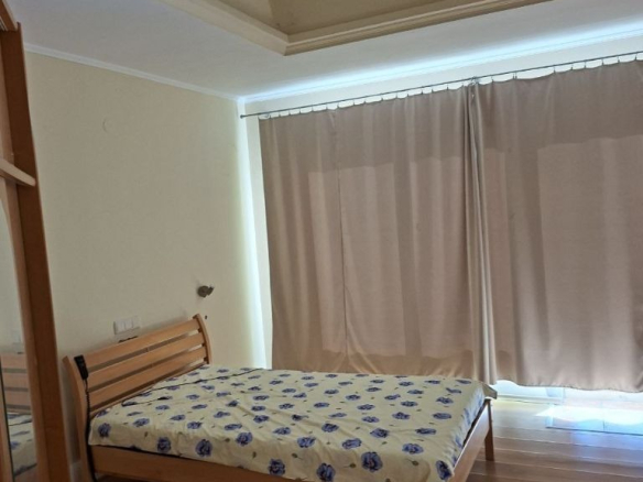 Spacious bedroom with wooden bed and modern ceiling