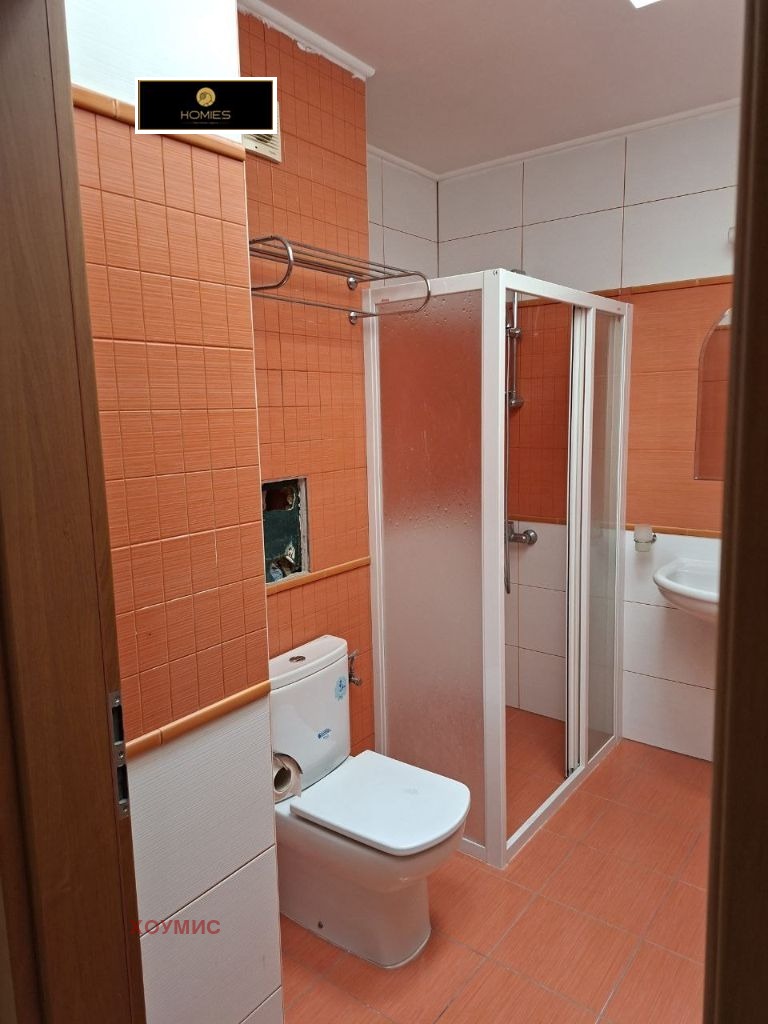 Orange tiled bathroom with shower cabin and toilet