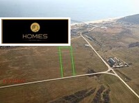 Равна парцел земя с оградени граници наблизо