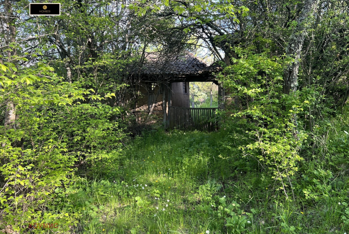 Полусрушена сграда с бели стени и дървена верандка