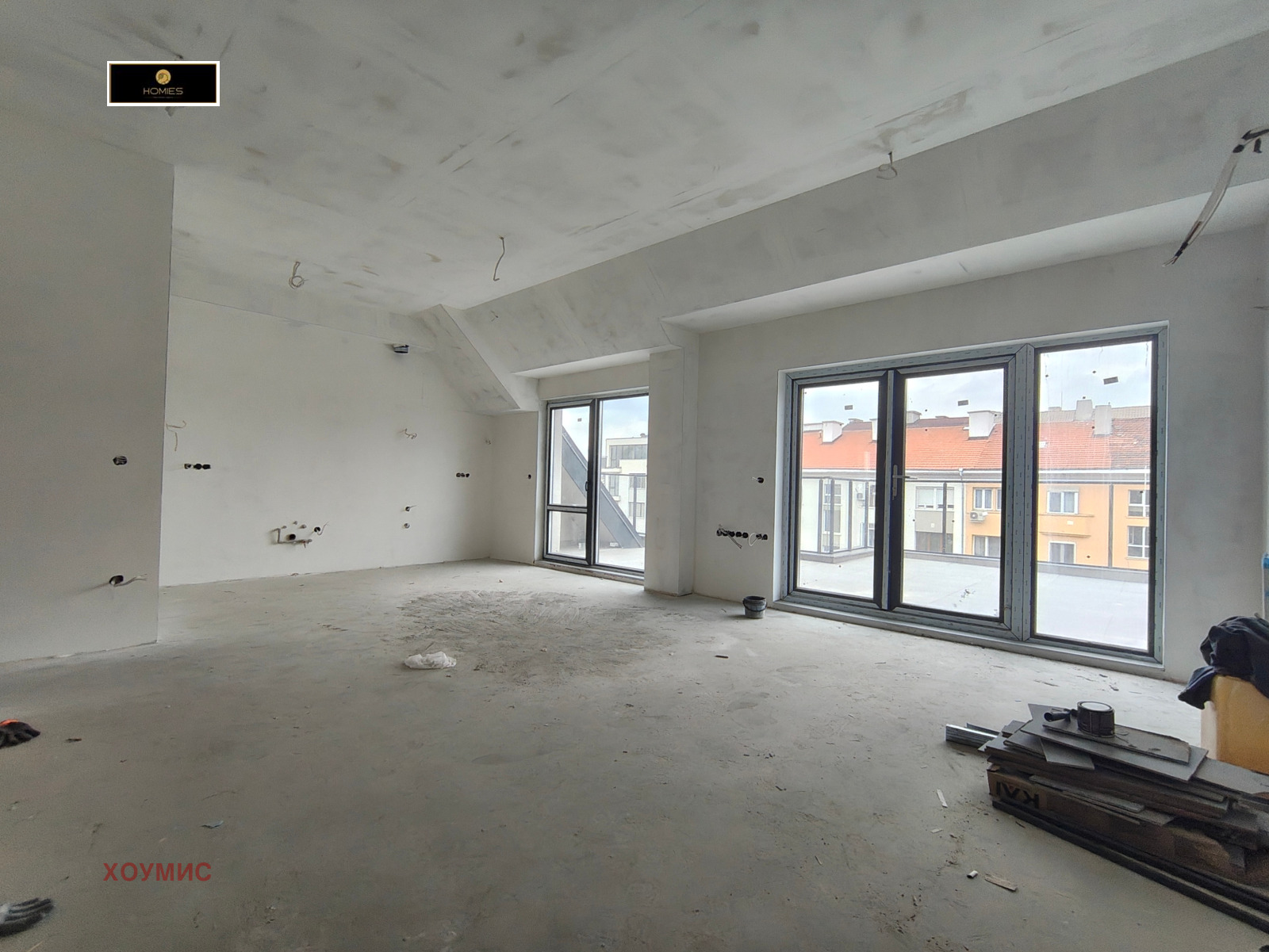 Spacious living room with three windows overlooking city