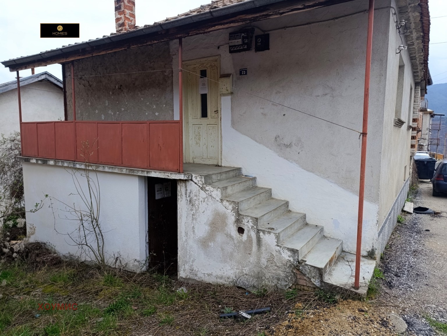 Small house with red veranda and concrete steps