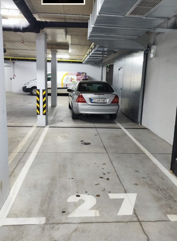 Underground parking space 27 with silver car parked