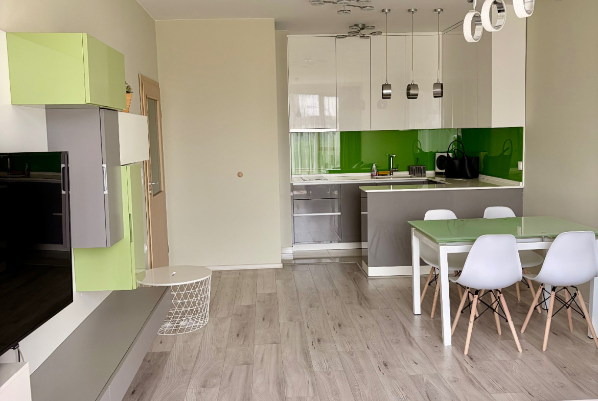 Modern kitchen with green backsplash and white cabinets