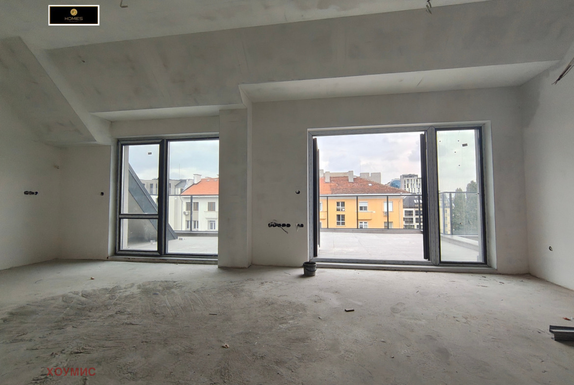 tristaen-apartament-90-kvm-prodava-se-sofiya-tsentar-dve-terasi-4 Дневна с мансардни прозорци и достъп до тераса
