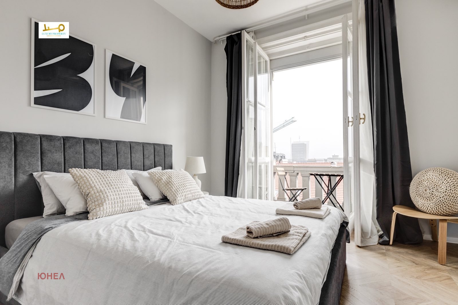 Bedroom with gray upholstered headboard and panoramic terrace